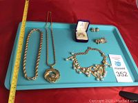 Full lot layout showing three necklaces, ring in a box, pin, and two pairs of earrings on a blue tray with measuring tape for size reference.
