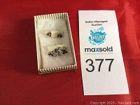 Two pairs of pierced earrings in a small box with MaxSold auction card visible.