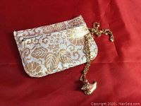 Chain and pouch laid out on red fabric background