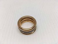 Close-up photo of the rose gold ring showing three bands and size marking inside.