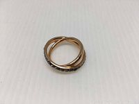 Gold-tone metal Swarovski Dynamic ring with black crystals on one band, photographed on white background.