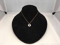 Front view of the Swarovski crystal key pendant necklace displayed on a black velvet bust.