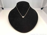 Swarovski heart pendant displayed on black necklace bust stand, showing full chain and pendant details