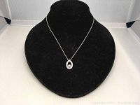 Front view of the Swarovski crystal pendant necklace displayed on a black velvet bust form against a white background.