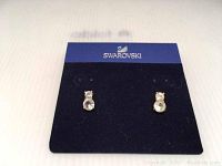 Pair of Swarovski pierced earrings on blue-black display card with brand name