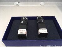 Two NARS sheer lipstick tubes labeled Damage and Chelsea Girl in a blue box.