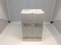 Four stacked boxed units of RéVive broad-spectrum SPF 50 sunscreen, showing front side of the packaging with brand and size information.