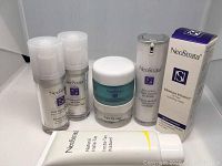 Seven NeoStrata skincare products on white background including bottles, tubs, and tubes, one boxed item.