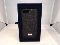 Front view of the black Swarovski phone case glittering with crystals inside original blue box.