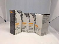 Four boxed Neostrata Enlighten skincare products: two Brightening Eye Creams and two Illuminating Serums shown from front angle.