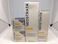 Four Neostrata skincare product boxes with Vitamin C Concentrate capsules, Ultra Brightening Cleanser, and Brightening Complex on white backdrop.