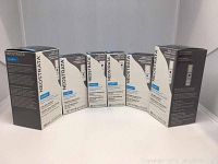 Photo of six boxed Neostrata Clarify skincare products arranged in a line against a white background.