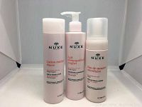 Front view of three NUXE Paris skincare bottles: Gentle Toning Lotion, Comforting Cleansing Milk in pump bottle, and Micellar Foam Cleanser.