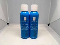 Two blue spray bottles of La Roche-Posay Serozinc purifying mist with white caps, front view showing labels and product details.