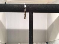 Bracelet hanging on a black display T-bar stand, showing the side view of the continuous Swarovski crystal circle design.