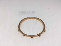 Single copper plated rhodium bracelet with embedded clear crystals placed on white background.