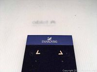 Pair of Swarovski V-shaped crystal-filled stud earrings displayed on a blue Swarovski branded card.