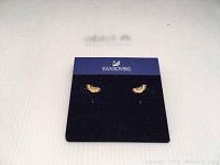 Pair of Swarovski butterfly earrings on a black branded card backing, showing front detail of small gold-tone earrings with crystal accents.