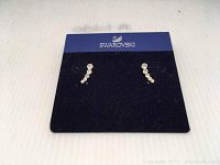 Front view of the Swarovski earrings on a blue Swarovski branded card holder, showing the crystal design.