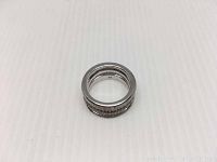 Photo of the Swarovski silver rhodium crystal ring on a white ribbed surface showing the three-tier band design.