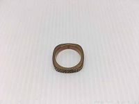 Rose gold-tone Swarovski ring shown laying flat on a white surface. The ring has a square silhouette with small crystals embedded on the outer band.