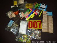 Overview of assorted craft supplies including beads, markers, glue sticks, ribbon, scissors, and popsicle sticks.