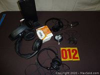 Photo showing all headphones, earbuds, and FM radio headset displayed together on a dark surface.