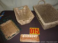 Photo showing four baskets of various sizes and styles including one large rectangular basket, a medium basket with handle, a metal-framed basket, and a small narrow basket.