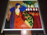 Full view of the colorful lithograph showing a woman in a blue hat and red dress seated on a patterned chair