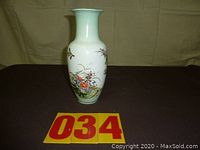 Full view of the Japanese flowered vase showing floral and bird designs on the vase body with a light green neck and base.