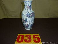 Full view of the ceramic vase showing the overall shape, color scheme and fish motifs