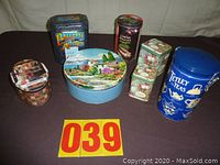 Seven assorted collector tins of various sizes and themes arranged together for display