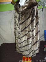 Front view of the faux fur coat on a mannequin showing diagonal stripe pattern and hood.