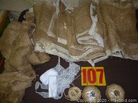 Photo showing folded burlap runners with white lace trim and smaller pieces of lace and burlap on table surface.