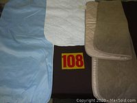 Quilted and soft fabric adult bed and chair protectors laid flat with red-yellow lot number 108.