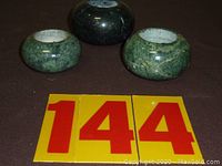 Three green stone tea light holders in small, medium, and large sizes, placed with '144' number tags to identify the lot
