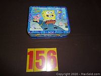 Top view of the SpongeBob SquarePants metal lunch box showing SpongeBob, Patrick, Sandy, and Gary graphics.