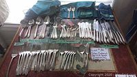 Overall view of all silver plated flatware pieces laid out on table
