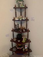 Full view of the wooden corner shelf with various decorative items on the shelves, showing the shape, size, and design.