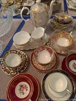 Overhead shot of Queen Anne teapot, creamer, sugar bowl and eight tea cup and saucer pairs arranged