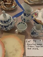 Steatita cream pitcher, sugar bowl, small cup, blue floral decorative motif, accompanied by assorted saucers and a note of lot contents