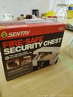 Photo of the boxed Sentry fire-safe security chest showing branding, model 1100 and fire-safe security chest labeling.