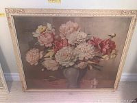 Floral painting in ornate cream frame showing pink, white, and red peonies in vase.