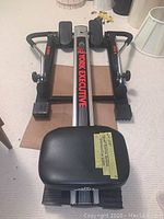 Rowing machine laid flat showing the seat, hydraulic resistance cylinders, footplates, and frame labeled York Executive X3500