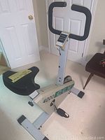 Full view of stationary exercise bike showing frame, seat, handlebars, pedal and monitor