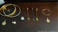 Overview of bracelets, earrings, pendants and pins arranged in a row