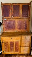 Front view of entire cabinet showing upper three-door cupboard and lower drawers and doors