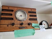 Front view of vintage-inspired Crosley radio with wood finish, tuning dial, three control knobs, and speaker mesh. Green tape label marked 'working.'