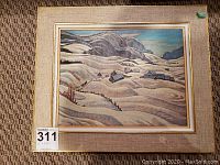 Full framed print with beige fabric mat and gold trim around the print featuring a snowy mountainous landscape with scattered houses.