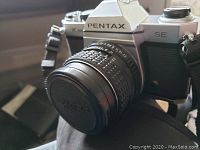 Front view of Pentax SE with attached lens and camera strap
